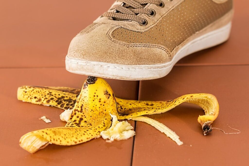 Pé masculino prestes a pisar em casca de banan no chao